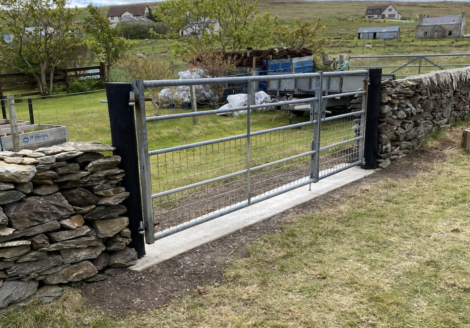 A stone gate in the middle of a field.