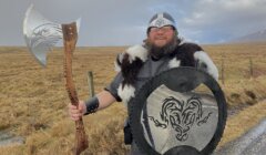 A man dressed as a viking holding an axe.