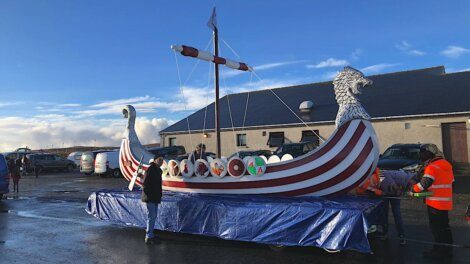 A large viking ship is parked in a parking lot.