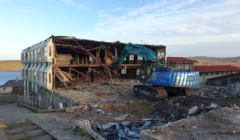 A building is being demolished by a bulldozer.