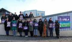 A group of people holding signs in front of a building.