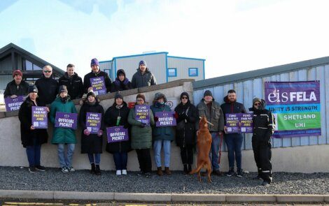 A group of people holding signs in front of a building.