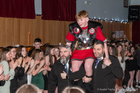 A boy is being carried by a man in a costume.