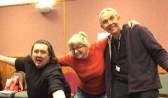 Three people posing for a photo in a room.