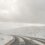 A car driving down a snow covered road.