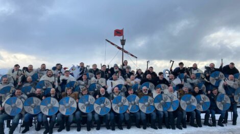 A group of people posing for a photo with viking shields.