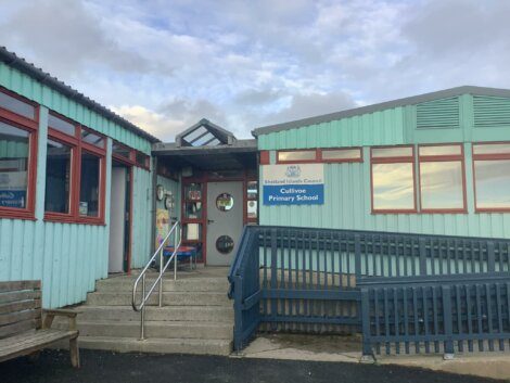 A blue building with a bench in front of it.