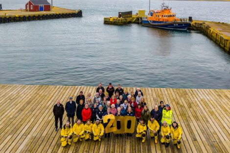 A group of people standing on a dock with a number on it.