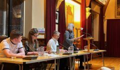 Panel discussion in an ornate room with a speaker at the podium and attentive panelists.