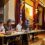 Panel discussion in an ornate room with a speaker at the podium and attentive panelists.