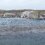 Harbor with boats and buildings on an overcast day with visible water level rising over the dock.