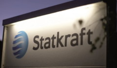 A sign for Statkraft featuring its logo, illuminated against a dark background.