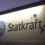 A sign for Statkraft featuring its logo, illuminated against a dark background.