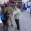 People attending an indoor expo, engaging in conversations with various informational posters and display booths in the background.