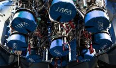 A close-up view of several rocket engines covered with blue protective covers labeled "RFA Rocket Factory" inside a spacecraft assembly area.