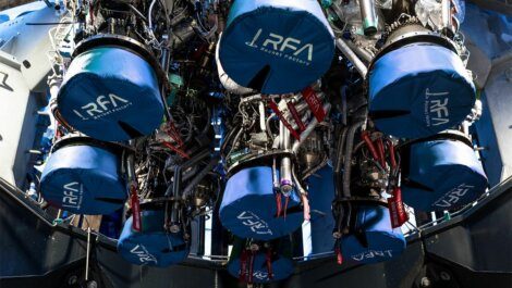 A close-up view of several rocket engines covered with blue protective covers labeled "RFA Rocket Factory" inside a spacecraft assembly area.