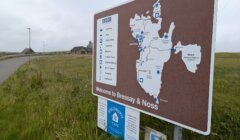 A signboard at the entrance of Bressay & Noss displays a map of the area with information on various landmarks and services.