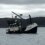 A fishing boat labeled "LK 331" floating in a body of water with hilly terrain in the background under a cloudy sky.