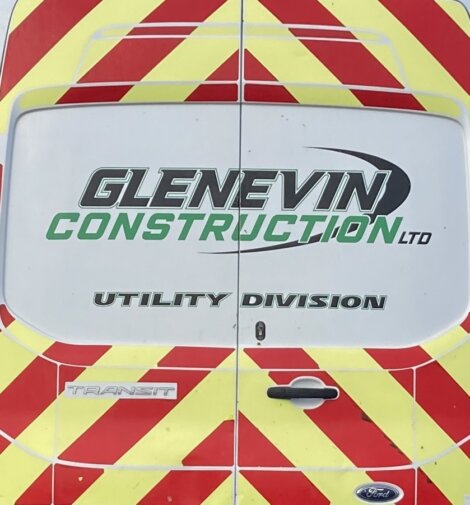 Back of a van with red and yellow chevron pattern. Text reads: "GLENEVIN CONSTRUCTION LTD UTILITY DIVISION" with a Ford logo at the bottom.