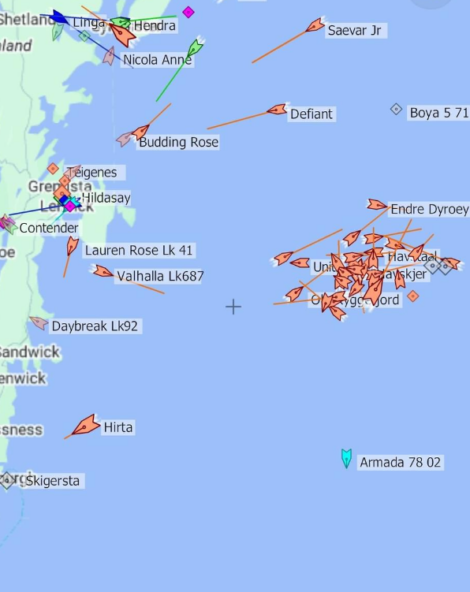 Map showing the locations and names of various ships in the North Sea, near Scotland and Shetland Islands. Ships are represented by orange arrows with many clustered east of the Shetland Islands.