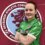 A soccer player stands confidently with arms crossed in front of a Dryburgh Athletic Community Club emblem.