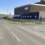 Street intersection with Gremista Road and a nearby industrial building in the background on a clear day.