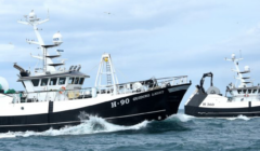 Two fishing boats, H-90 and H-360, navigate through the ocean under a cloudy sky.