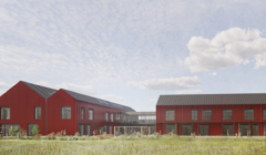 A modern building complex with red exterior, black roofs, and large windows, set in a grassy landscape under a partly cloudy sky.