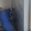 Person in blue coveralls installs insulation boards on a wall.