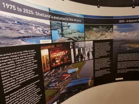 Curved display board showing text and photos about Shetland's oil era from 1975 to 2025, including landscapes, oil facilities, and local scenes.
