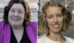 Two women shown side by side; the left is wearing a pink blazer outdoors by water, the right is wearing a light jacket on a street with colorful flags above.