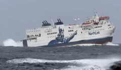 A NorthLink ferry travels through rough seas, with waves crashing against its hull and a Viking graphic painted on the side.