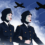 Illustration of two women in dark wartime-style uniforms with peaked caps, walking arm in arm against a blue sky with clouds, while three