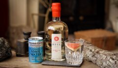 A bottle of Shetland Reel Gin (Up Helly Aa 2022) stands beside a can of Fever-Tree Mediterranean Tonic Water and a glass with ice and a