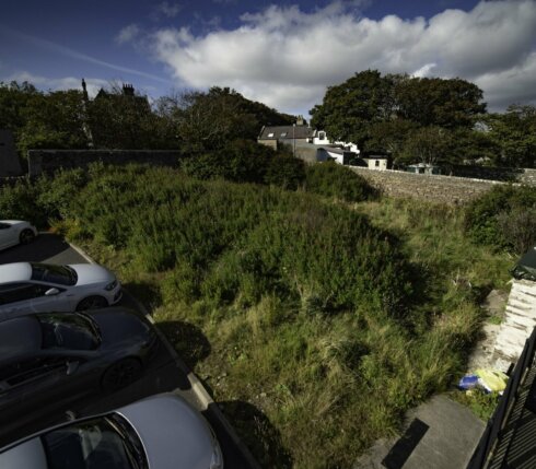 An aerial view of a parking lot with cars parked in it.